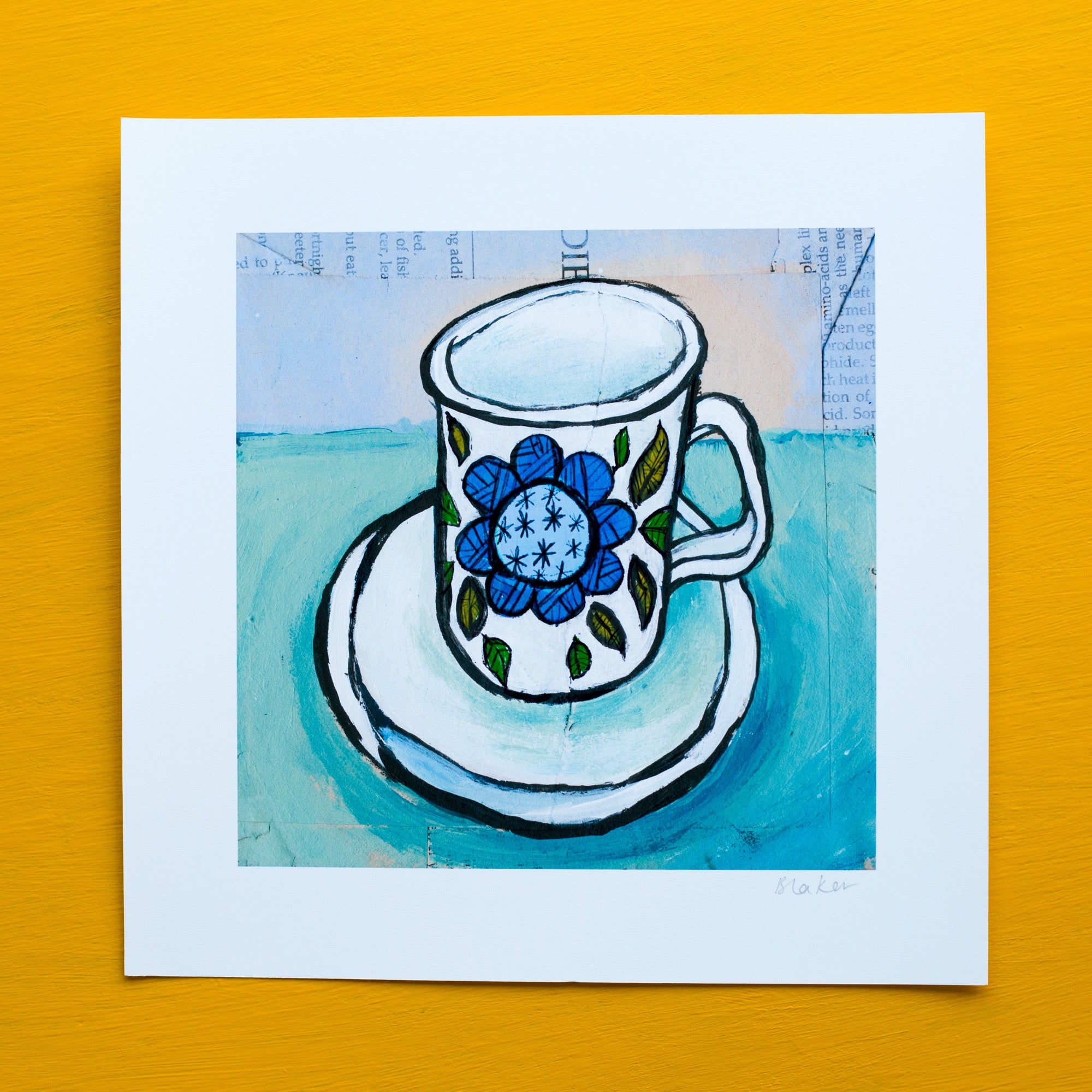 a wonky white teacup on saucer with a blue flower on it and green leaves. the background is pale blue and collaged book pages are visible under the paint 